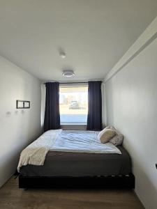 雷克雅未克Apartment near Reykjavik's heart的窗户客房内的一张床位