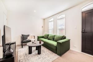 基督城Retro Retreat in Christchurch的客厅配有绿色沙发和桌子