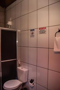 戈亚斯州上帕莱索Pousada Chalés Além do Paraíso的浴室设有卫生间,墙上设有标志