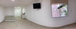 圣米格尔·德·图库玛GMP Suites的客厅配有沙发和墙上的电视