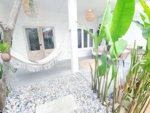 苏梅岛3BR Villa, Bangrak Beach, Koh Samui的一间设有吊床和一些植物的房间