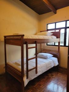基多Casa Colon Quito Bed & Breakfast Hostel的带窗户的客房内的两张双层床