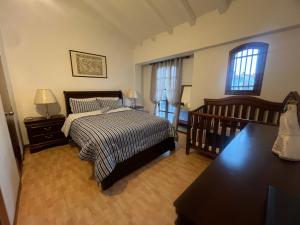 El Morro de BarcelonaPueblo Viejo Lecheria的一间卧室配有一张床、一张桌子和两个窗户