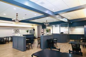 萨德伯里Days Inn by Wyndham Sudbury & Conference Centre的餐厅拥有蓝色的天花板和桌椅