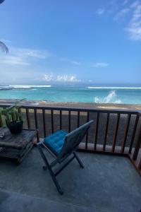 甘地达萨Villa Tara villas的俯瞰海滩的阳台的椅子
