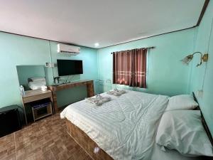 Ban Hin Latสวนสบายปลายนารีสอร์ท的一间卧室配有一张床和一台电视