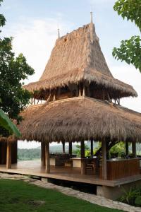 Patiala BawaSumbaFarmHouse的茅草屋顶的大型小屋