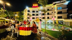 Cham Ta LaoHeaven Hill Hotel & Hot Spring的一群人晚上坐在泳池附近的桌子旁