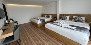 万荣Vang Vieng Bungalows的酒店客房设有两张床和电视。