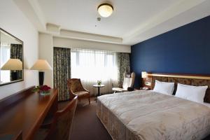 知立市知立皇冠饭店的酒店客房设有一张大床和一张书桌。