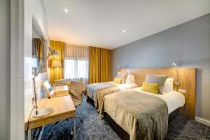 格拉斯哥Apex City of Glasgow Hotel的酒店客房配有两张床和一张书桌