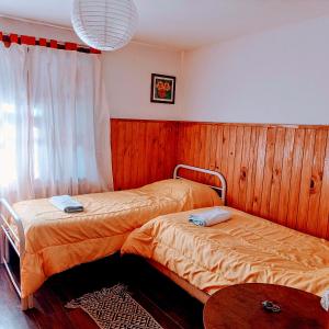 圣卡洛斯-德巴里洛切Hospedaje BRC的木镶板客房内的两张床