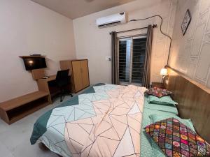 勒克瑙GREEN HOME STAY的一间卧室配有一张床和一张书桌