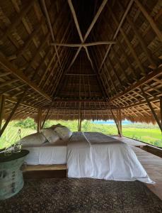 Patiala BawaSumbaFarmHouse的卧室内茅草屋顶下的一张床