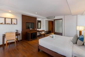 芭东海滩Baan Laimai Beach Resort & Spa - SHA Extra Plus的酒店客房 - 带一张床和用餐室