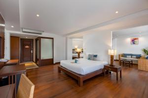 芭东海滩Baan Laimai Beach Resort & Spa - SHA Extra Plus的一间带大床的卧室和一间客厅