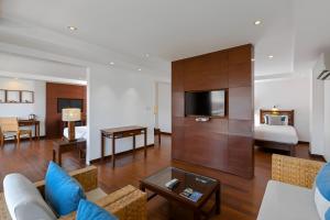 芭东海滩Baan Laimai Beach Resort & Spa - SHA Extra Plus的带沙发的客厅和卧室