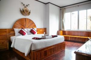 武里南Sky View Hotel Buriram的一间卧室配有一张大床和木制床头板