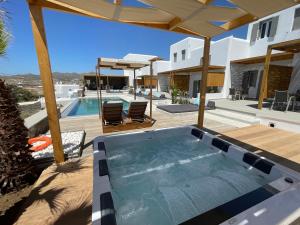 克洛瓦斯CASA DI PIETRA MYKONOS的一座房子内带热水浴池的游泳池