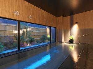 桑名市Hotel Route Inn Kuwana的一座带大窗户的建筑中的游泳池