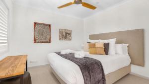 波高尔宾Hunter Dreaming的卧室配有一张白色大床和吊扇