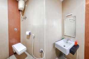 钦奈FabHotel Prime Mahalaya Residency的一间带水槽、卫生间和镜子的浴室
