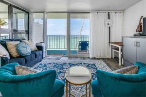 HauulaLuxury Beachfront with Breathtaking views & AC的客厅配有蓝色的家具,享有海景。