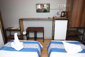 SeyhanThe Time Hotel Adana的一间房间,配有两张床和一张男人的照片