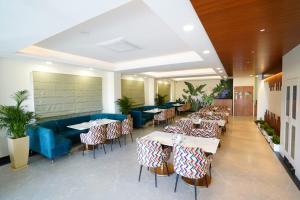 斋浦尔Cilantro Comfort Jaipur的一间带桌椅和蓝色沙发的餐厅