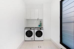 科夫斯港Elvis on Brodie - luxury boutique accommodation的白色洗衣房配有洗衣机和烘干机