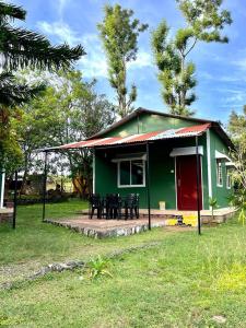 马西尼古蒂Sampala Resort的绿色房子,配有黑色椅子和红色门
