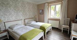 PrierosCellino Hotel Prieros的一间卧室设有两张床和窗户。