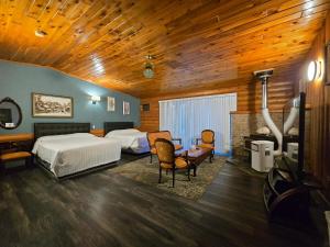维勒蒙特阿尔卑斯旅馆的一间卧室配有两张床和一张桌子及椅子