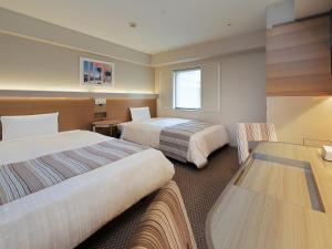 东京Keio Presso Inn Otemachi的酒店客房设有两张床和一张桌子。