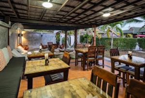 班泰帕查里度假村的一间带木桌和椅子的餐厅以及庭院
