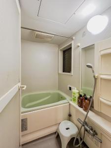 东京Tranquil Tokyo Retreat #Spacious 3BR House in Hiroo的一间带绿色浴缸和卫生间的浴室
