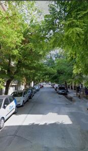 塞萨洛尼基Thessaloniki Amazing Apartment的一条树木成荫的街道上,街上有汽车停放
