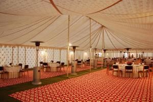 阿拉哈巴德Shivadya Camps MAHAKUMBH Mela的一个带桌椅的大型帐篷