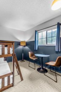 邓斯缪尔The Angler Lodge的卧室配有一张床和一张桌子及椅子
