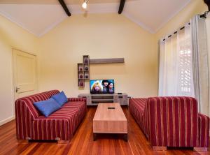 内罗毕A PLACE OF TRANQUILITY, Muthaiga的客厅配有2张红色沙发和电视