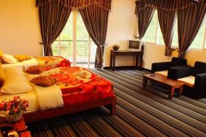 努沃勒埃利耶New Ashley Resorts (PVT) LTD的一间卧室配有两张床、一张沙发和一张书桌