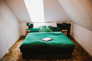 PoniatowaStacja Kultura的阁楼上一间卧室配有绿色的床