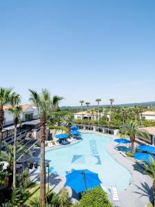 西归浦市Hotel Toscana的棕榈树度假村泳池的空中景致