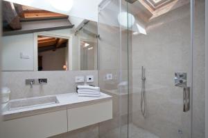 索纳Relais Corte Guastalla Apartments的一间带水槽和玻璃淋浴的浴室