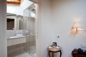 索纳Relais Corte Guastalla Apartments的一间带玻璃淋浴和水槽的浴室