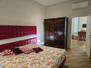 维罗纳Verona Romeo's Eye的一间卧室配有一张大床和红色床头板