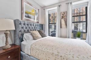 纽约Spacious 4 Bedroom Apartment的一间卧室设有一张床和两个窗户。