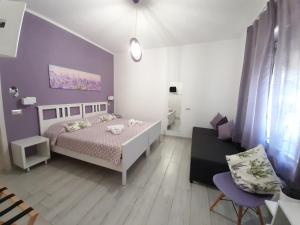 马西亚娜马里纳B&B Capo al Piano的卧室配有白色的床和紫色墙壁