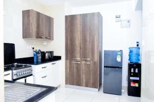 马查科斯Amalia Apartments Syokimau的厨房配有木制橱柜和不锈钢冰箱。