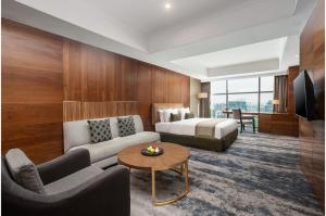 棉兰棉兰阿里亚酒店的酒店客房配有床、沙发和桌子。